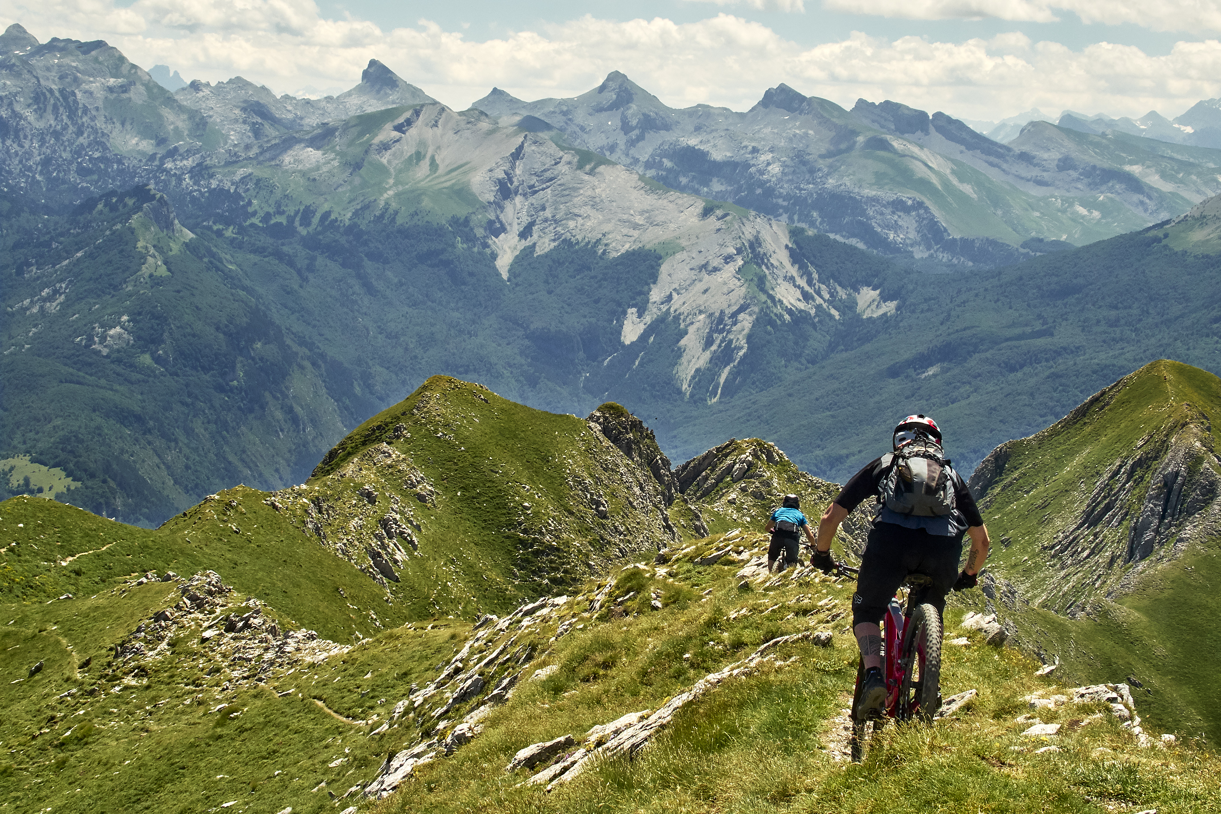 Dos ciclistas bajando por la cresta de un monte